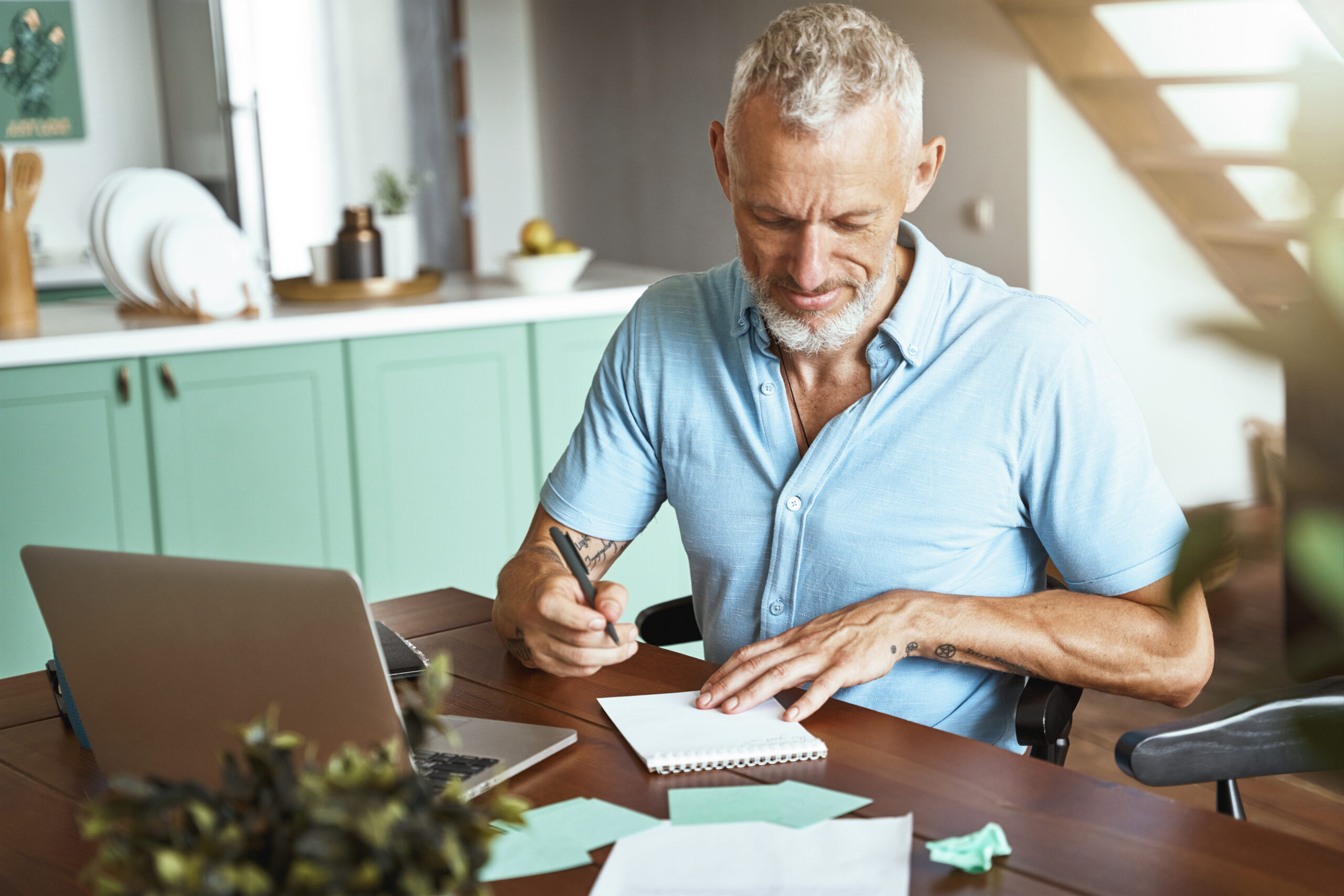 Focused Middle Aged Caucasian Man Making Some Notes While Sitting